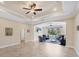 Bright living room featuring tile floors, tray ceiling, and large windows overlooking the backyard at 576 Box Elder Ct, Englewood, FL 34223