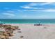Scenic beach view featuring rocks, serene ocean, and beachgoers enjoying the tranquility of the coastal setting at 70 Wilhelm Dr, Englewood, FL 34223