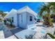 A quaint blue house with an outdoor shower, landscaping and white rock and blue tile pathway at 70 Wilhelm Dr, Englewood, FL 34223
