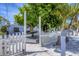 Charming home with a white picket fence, mature landscaping and an inviting outdoor lounging area at 70 Wilhelm Dr, Englewood, FL 34223