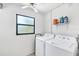 Laundry room featuring a window, shelving, a washing machine and a dryer at 70 Wilhelm Dr, Englewood, FL 34223