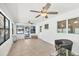 Well-lit living room featuring tiled floors, multiple ceiling fans, and a view of the outdoors at 70 Wilhelm Dr, Englewood, FL 34223