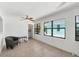 Bright living room with modern windows, ceiling fan, tiled floors and a chair and table at 70 Wilhelm Dr, Englewood, FL 34223