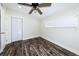 Bedroom showcases wood-look floors, a ceiling fan, and a bright window overlooking the front yard at 700 Floral Ln, Port Charlotte, FL 33952