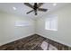 Bedroom features dark wood floors, a ceiling fan, and two windows at 700 Floral Ln, Port Charlotte, FL 33952
