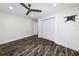 This bedroom features dark wood-look floors, a ceiling fan, and a closet at 700 Floral Ln, Port Charlotte, FL 33952