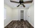 Bedroom features dark wood floors, a ceiling fan, and an open closet at 700 Floral Ln, Port Charlotte, FL 33952