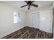 Bedroom features dark wood floors, a ceiling fan, and a window view at 700 Floral Ln, Port Charlotte, FL 33952