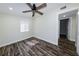 Cozy bedroom featuring dark wood-look flooring, white trim, and a ceiling fan with lights at 700 Floral Ln, Port Charlotte, FL 33952