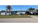 Single story home with a lawn, palm tree and an RV parked in the driveway at 700 Floral Ln, Port Charlotte, FL 33952