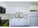 Bright kitchen features white cabinets, stainless steel appliances, and modern countertops at 700 Floral Ln, Port Charlotte, FL 33952