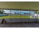 Screened patio offers views of the green backyard and white fence at 700 Floral Ln, Port Charlotte, FL 33952