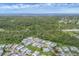 An aerial view shows a well-maintained mobile home community surrounded by lush greenery and waterways at 742 Portwine Ct # 17, Englewood, FL 34223