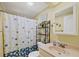 Bright bathroom featuring a vanity, toilet, shelving unit, and a shower with a decorative curtain at 742 Portwine Ct # 17, Englewood, FL 34223
