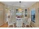 Charming dining room with a glass table and wicker chairs with a view into the bedroom at 742 Portwine Ct # 17, Englewood, FL 34223