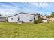 Exterior side view of the home showcasing the large yard, siding, and air conditioning unit at 742 Portwine Ct # 17, Englewood, FL 34223