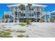 Charming two-story beach house with white stairs leading to decks on a sunny day at 7554 Palm Island S Dr # 1813, Placida, FL 33946