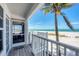 Charming porch view featuring white railings, wood decking, and ocean views beyond a palm tree at 7554 Palm Island S Dr # 1813, Placida, FL 33946