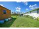 Wide backyard featuring a shed, a patio area with chairs, and open lawn at 7690 Castleberry Ter, Englewood, FL 34224