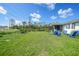 Backyard featuring a patio area with blue chairs, lawn, and open space at 7690 Castleberry Ter, Englewood, FL 34224