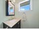 Updated bathroom featuring a marble vanity top, decorative mirror, and modern faucet at 7690 Castleberry Ter, Englewood, FL 34224