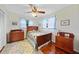 Bedroom with hardwood floors, wooden bed, side tables, and bright windows at 7690 Castleberry Ter, Englewood, FL 34224