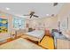 Cozy bedroom with hardwood floors, ceiling fan, and large window providing natural light at 7690 Castleberry Ter, Englewood, FL 34224