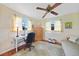 Spacious bedroom featuring a ceiling fan, hardwood floors, and a comfortable seating area at 7690 Castleberry Ter, Englewood, FL 34224