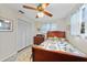 Cozy bedroom featuring a wooden bed frame, ceiling fan, and closet with bi-fold doors at 7690 Castleberry Ter, Englewood, FL 34224