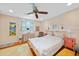 Bright bedroom features hardwood floors, ceiling fan, and comfortable furnishings at 7690 Castleberry Ter, Englewood, FL 34224