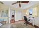 Bedroom with a desk area, ceiling fan, hardwood floors, and natural light from the window at 7690 Castleberry Ter, Englewood, FL 34224