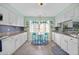 Bright kitchen featuring white cabinets, granite countertops, and a cozy breakfast nook at 7690 Castleberry Ter, Englewood, FL 34224