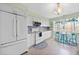 Functional kitchen with white cabinets, a cozy breakfast nook, and tiled flooring at 7690 Castleberry Ter, Englewood, FL 34224