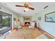 Comfortable living room with a cozy brick fireplace and sliding glass doors to the patio at 7690 Castleberry Ter, Englewood, FL 34224