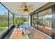 Inviting screened porch with fan, table, chairs, and views of the surrounding greenery at 7690 Castleberry Ter, Englewood, FL 34224