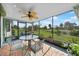 Relaxing screened porch featuring a ceiling fan, table and chairs, and a view of the backyard at 7690 Castleberry Ter, Englewood, FL 34224