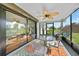 Screened porch with a ceiling fan, table and chairs, and view of the lush backyard at 7690 Castleberry Ter, Englewood, FL 34224