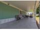 Covered back porch with outdoor seating and a golf cart at 8224 Pinetree Ln, Englewood, FL 34224