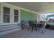Covered porch featuring outdoor dining area and golf cart parking at 8224 Pinetree Ln, Englewood, FL 34224