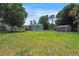 Spacious backyard with a well-maintained lawn and storage shed at 8224 Pinetree Ln, Englewood, FL 34224