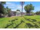 Charming single-story home with a lush lawn and mature trees under a sunny, blue sky at 8224 Pinetree Ln, Englewood, FL 34224