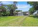 View of the home with a covered patio and a large yard at 8224 Pinetree Ln, Englewood, FL 34224