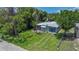 Cozy single-story home with well-kept lawn, shade trees, carport, and white picket fence at 8224 Pinetree Ln, Englewood, FL 34224