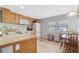 Functional kitchen features wood cabinets, updated appliances, and adjacent dining area with natural light at 8224 Pinetree Ln, Englewood, FL 34224