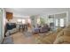 Bright living room with light wood floors, comfortable seating, and a view to the sunroom at 8224 Pinetree Ln, Englewood, FL 34224