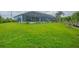 Expansive lawn leading to a screened enclosure at 10079 Lebanon Dr, Port Charlotte, FL 33981