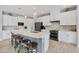Modern kitchen boasts a large island with seating, stainless steel appliances, and white cabinetry at 10079 Lebanon Dr, Port Charlotte, FL 33981