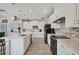 Bright kitchen with white cabinets, stainless steel appliances, and stone countertops at 10079 Lebanon Dr, Port Charlotte, FL 33981