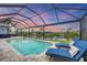 Enjoy outdoor living in this screened lanai with a pool and sun loungers overlooking the water at 10079 Lebanon Dr, Port Charlotte, FL 33981