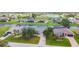 Breathtaking aerial view showcasing canal-front homes with manicured lawns, golf course and lake in the distance at 104 Mark Twain Ln, Rotonda West, FL 33947